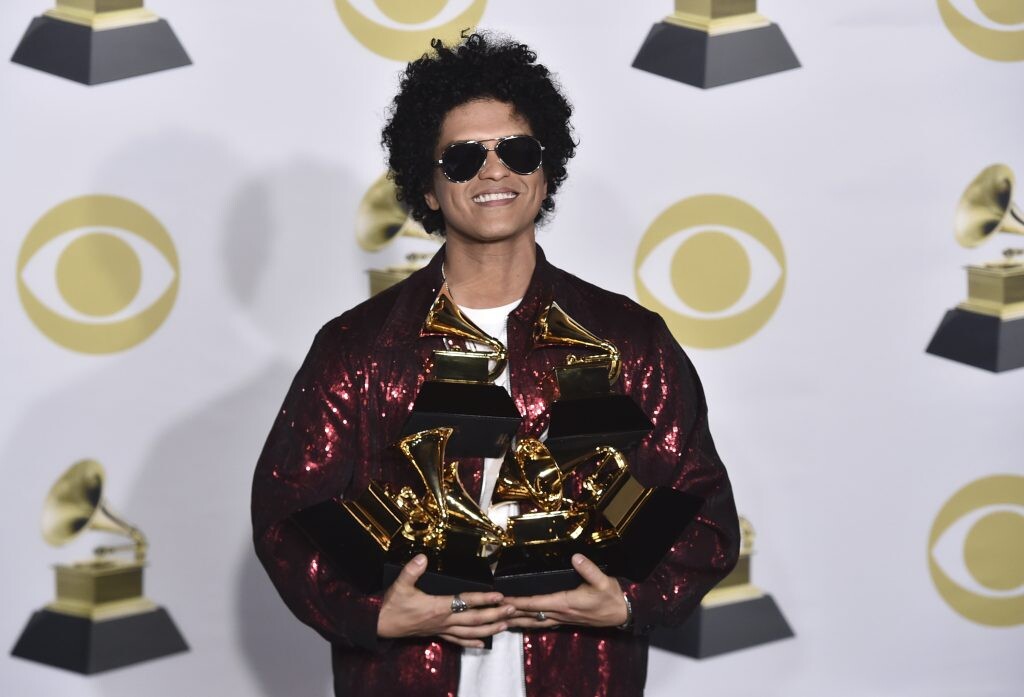 Bruno Mars drží v náručí plno cien.