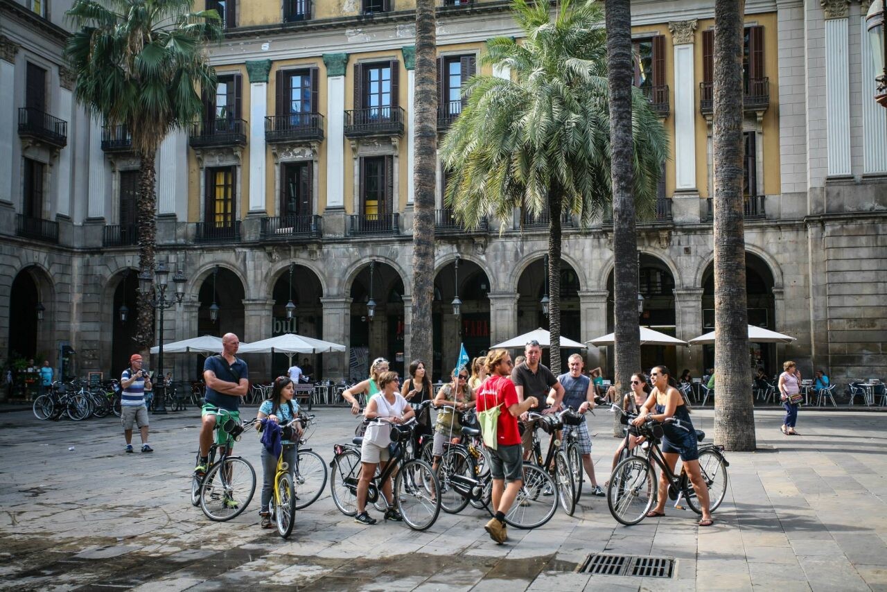 Ľudia na bicykloch pri prehliadke mesta. 