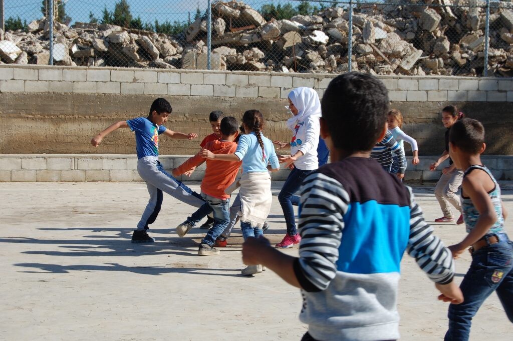 Sýrske deti sa hrajú na ihrisku. 