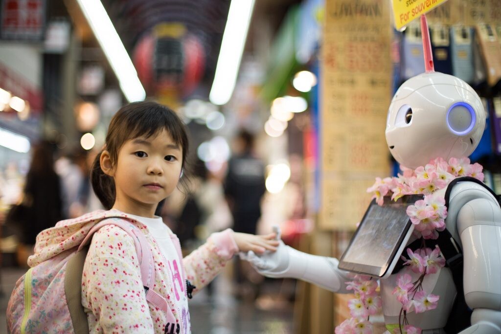 Robot drží za ruku malé dievčatko. 