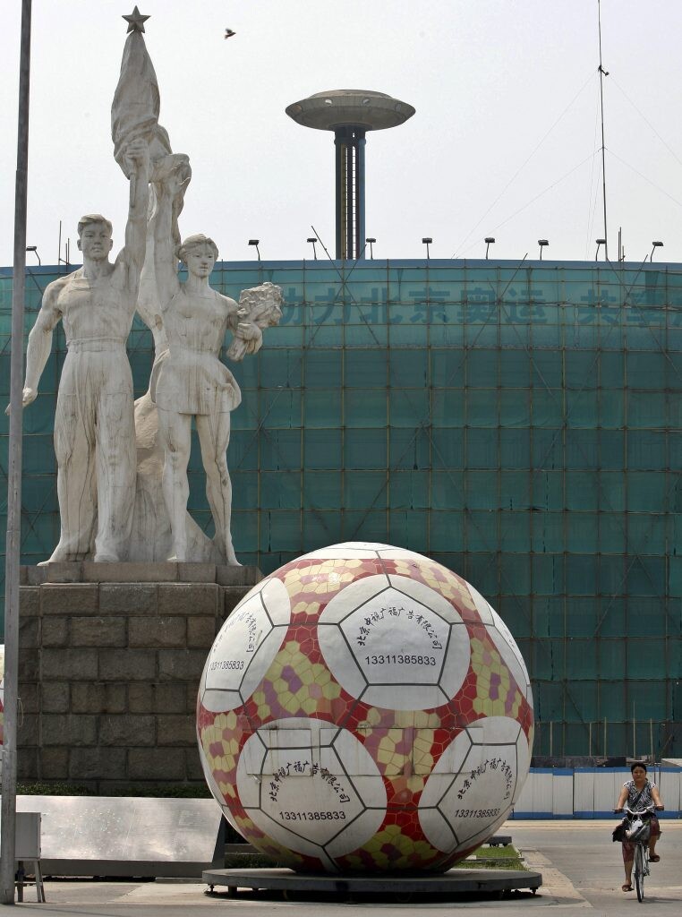 Čínsky štadión robotníkov počas rekonštrukcie v roku 2008. V popredí veľká futbalová lopta, v pozadí súsošie. 