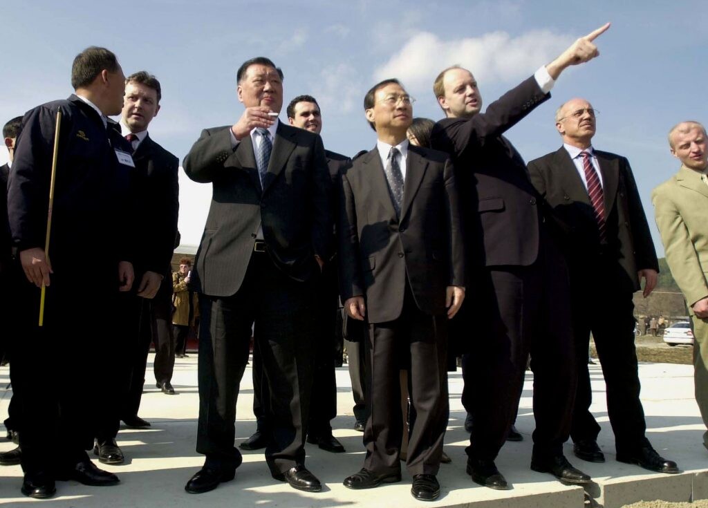 Fotka z roku 2004: stavenisko pri Žiline zažíva návštevu prezidenta Hyundai Kia Automotive Group Chung Mong-Koo (tretí zľava). Gestikuluje vtedajší minister hospodárstva Slovenska Pavol Rusko. 